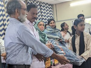 Sri Jose Parappilly , karunyavarsham and Smt Ruksana, Head Master Govt. H.S. Thevkal presenting school kit to the student